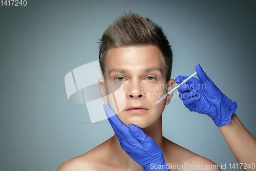 Image of Close-up portrait of young man isolated on grey studio background