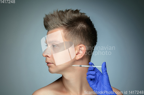 Image of Close-up portrait of young man isolated on grey studio background