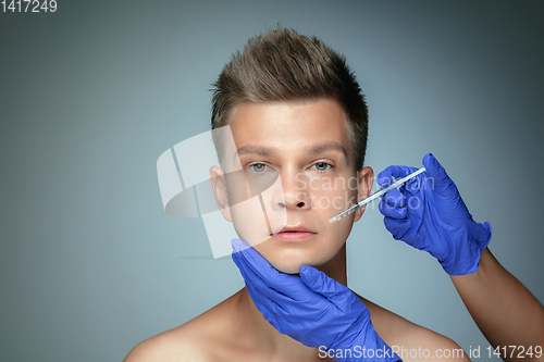 Image of Close-up portrait of young man isolated on grey studio background