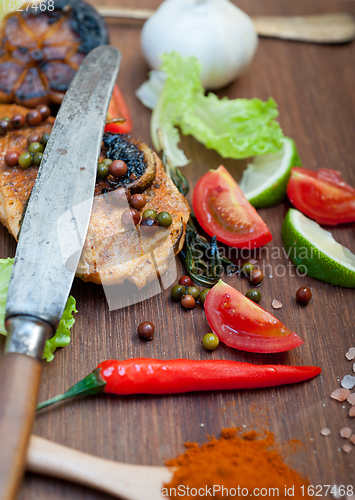 Image of wood fired hoven cooked chicken breast on wood board 