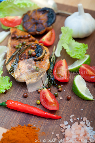 Image of wood fired hoven cooked chicken breast on wood board 