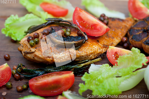 Image of wood fired hoven cooked chicken breast on wood board 