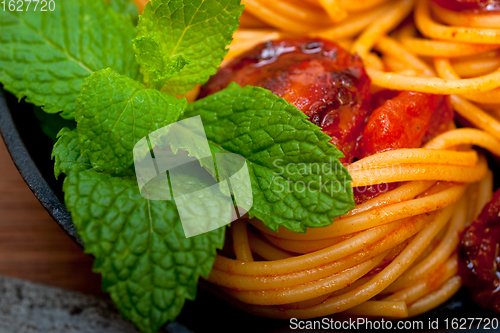 Image of italian spaghetti pasta and tomato with mint leaves 