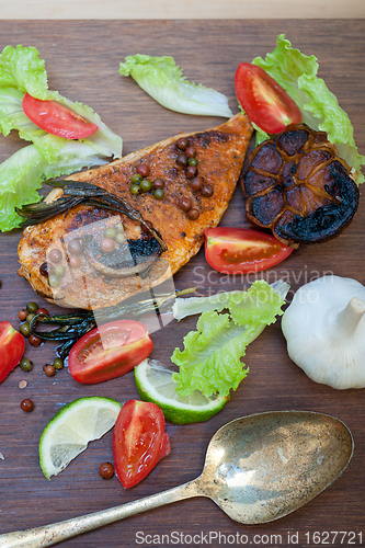 Image of wood fired hoven cooked chicken breast on wood board 