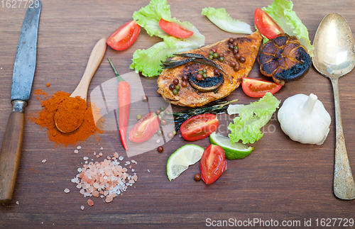 Image of wood fired hoven cooked chicken breast on wood board 