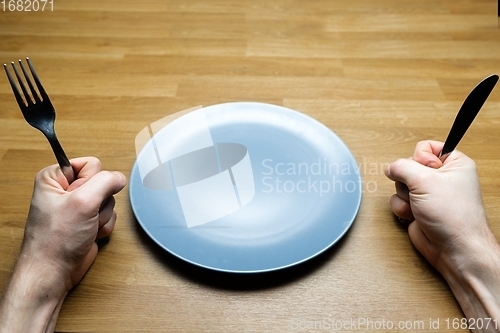 Image of Empty dish on table with man demanding some food
