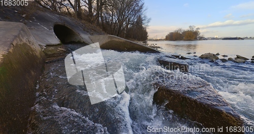 Image of Large sewage tunnel with filth flowing out