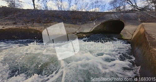 Image of Large sewage tunnel with filth flowing out