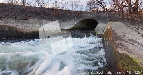 Image of Large sewage tunnel with filth flowing out