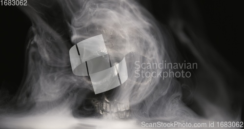 Image of Black skull in the darkness with smoke and fog