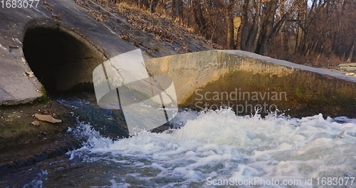 Image of Large sewage tunnel with filth flowing out