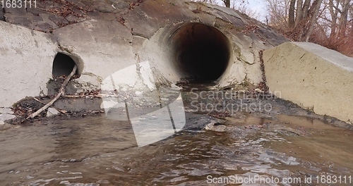 Image of Large sewage tunnel with filth flowing out