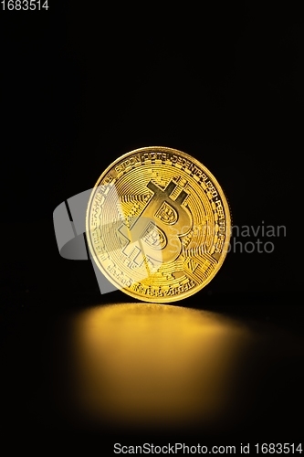 Image of Physical shiny bitcoin agains dark background