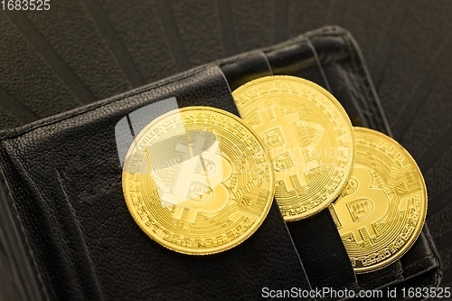 Image of Physical shiny bitcoin agains dark background in wallet