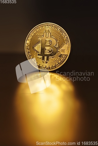 Image of Physical shiny bitcoin agains dark background