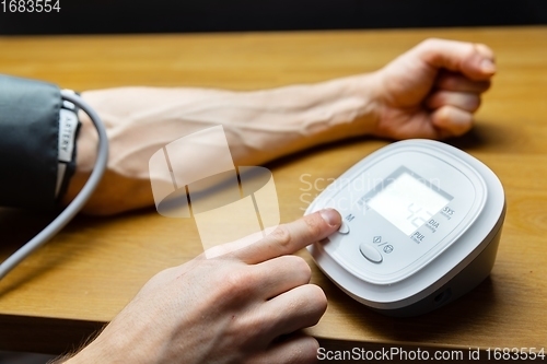 Image of Man measuring blood pressure closeup