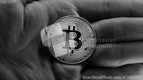 Image of Physical bitcoin held in hands closeup in black and white