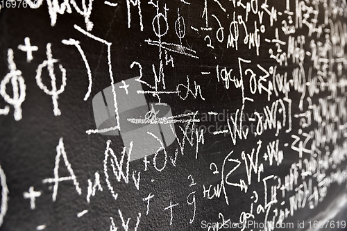 Image of Mathematical formulas on dark black chalk board