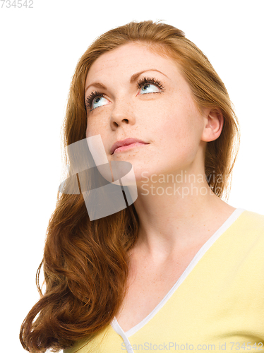 Image of Young happy woman is looking up and smile