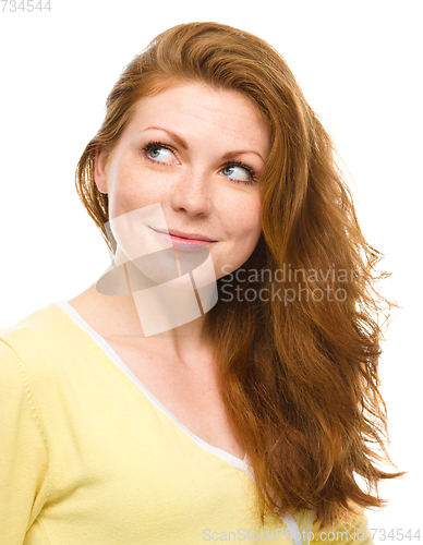 Image of Young happy woman is looking up and smile