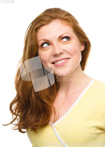 Image of Young happy woman is looking up and smile