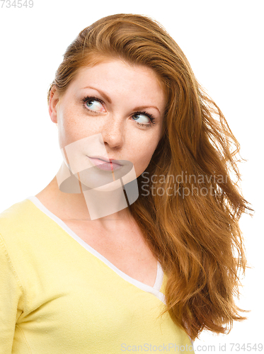 Image of Young happy woman is looking up and smile