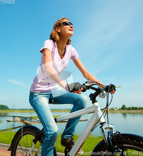 Image of Young woman is sitting on her bicycle