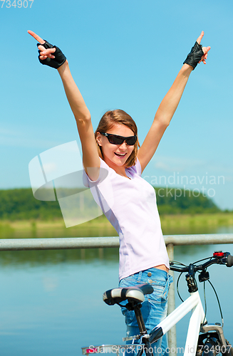 Image of Young woman raised her hands up in joy