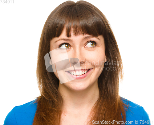 Image of Young happy woman is looking up and smile