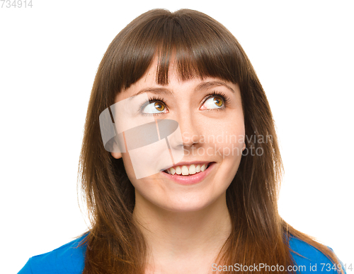 Image of Young happy woman is looking up and smile