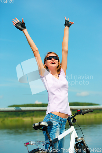 Image of Young woman raised her hands up in joy