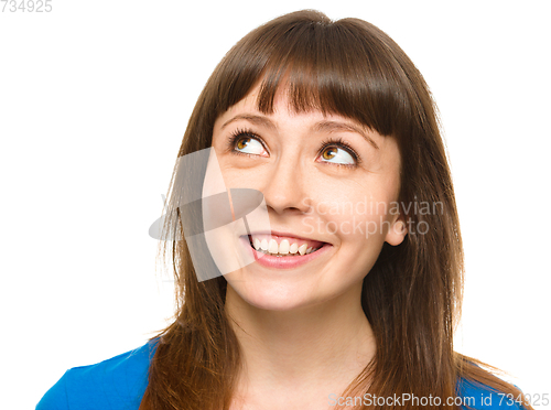 Image of Young happy woman is looking up and smile