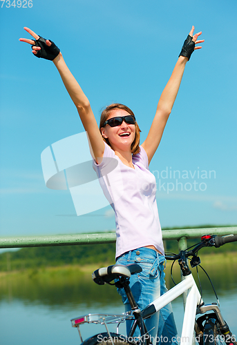 Image of Young woman raised her hands up in joy