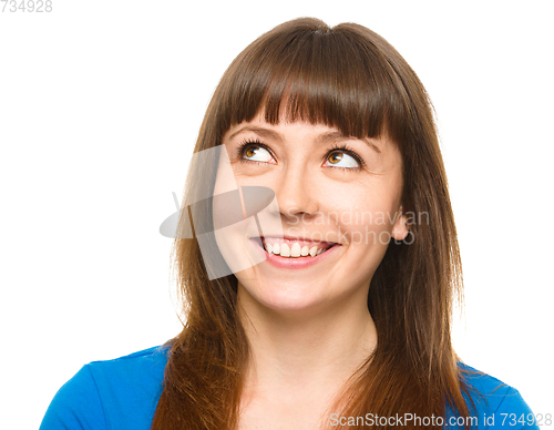 Image of Young happy woman is looking up and smile