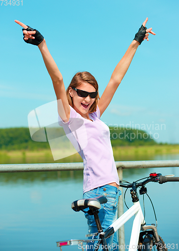 Image of Young woman raised her hands up in joy