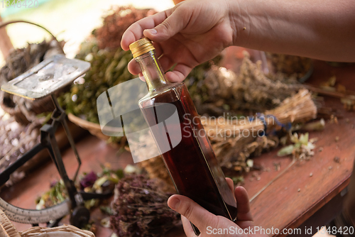 Image of potion bottle in hand of herbalist