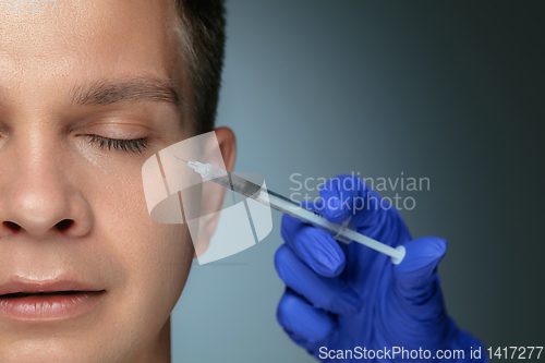 Image of Close-up portrait of young man isolated on grey studio background