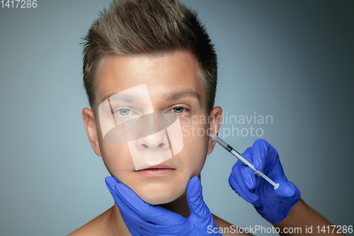 Image of Close-up portrait of young man isolated on grey studio background