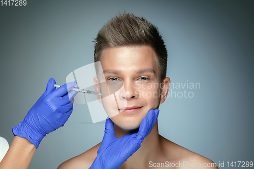 Image of Close-up portrait of young man isolated on grey studio background