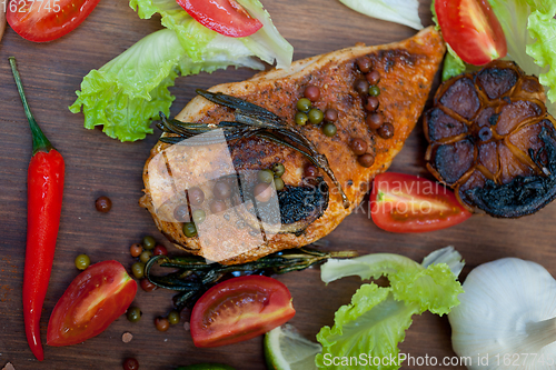 Image of wood fired hoven cooked chicken breast on wood board 