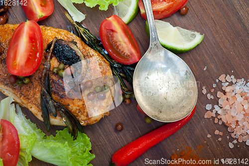 Image of wood fired hoven cooked chicken breast on wood board 