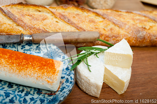 Image of French cheese and fresh  baguette on a wood cutter