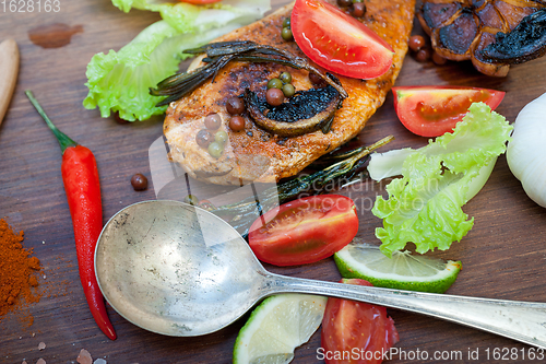 Image of wood fired hoven cooked chicken breast on wood board 