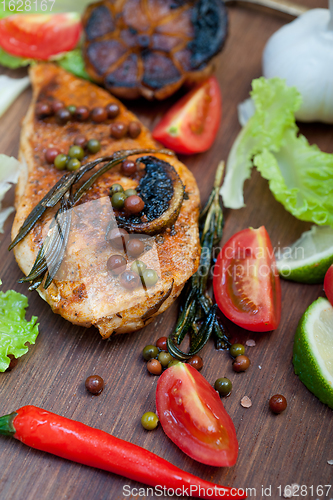 Image of wood fired hoven cooked chicken breast on wood board 