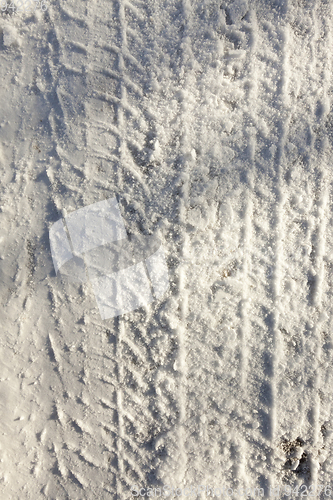 Image of the imprint of the car wheels on snow close-up