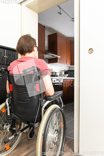Image of disabled woman at the open door to the kitchen