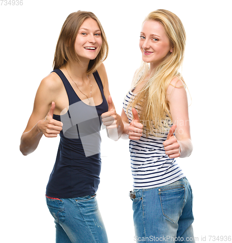 Image of Two young happy women showing thumb up sign