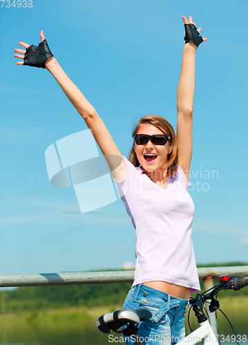 Image of Young woman raised her hands up in joy