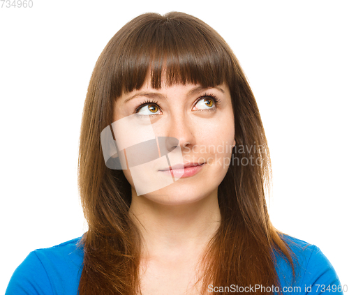 Image of Young happy woman is looking up and smile