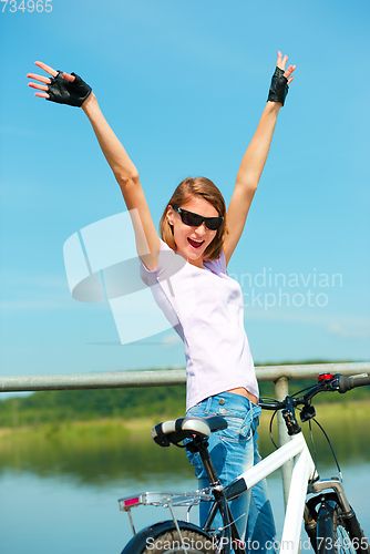 Image of Young woman raised her hands up in joy